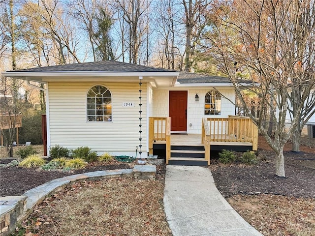 view of front of home featuring roof with shingles and a wooden deck