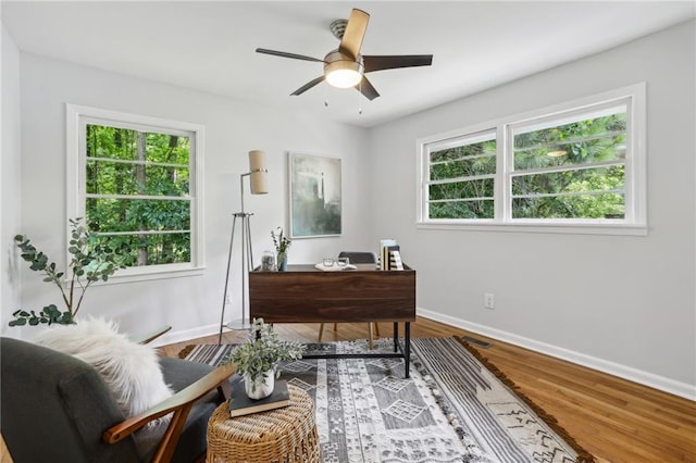 office space featuring ceiling fan, baseboards, and wood finished floors