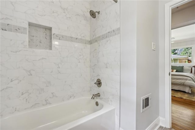 ensuite bathroom with ensuite bath, shower / tub combination, visible vents, and baseboards