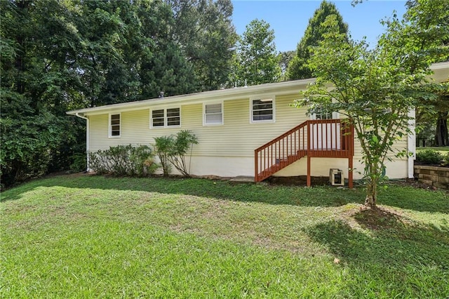 rear view of house with stairs and a lawn