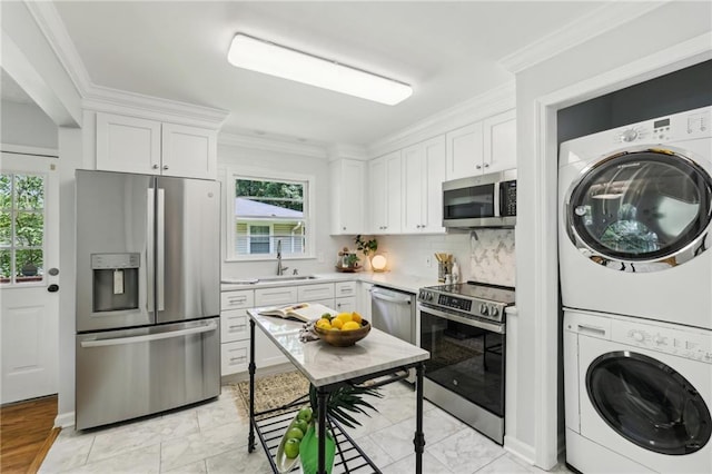 kitchen featuring stacked washer and dryer, white cabinetry, stainless steel appliances, and light countertops