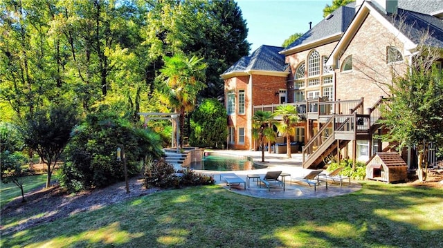 back of house with a pool side deck, a patio, and a lawn