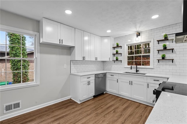 kitchen featuring white cabinetry, stainless steel dishwasher, sink, and hardwood / wood-style flooring