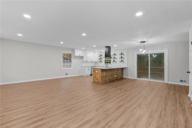 unfurnished living room with sink and light hardwood / wood-style flooring