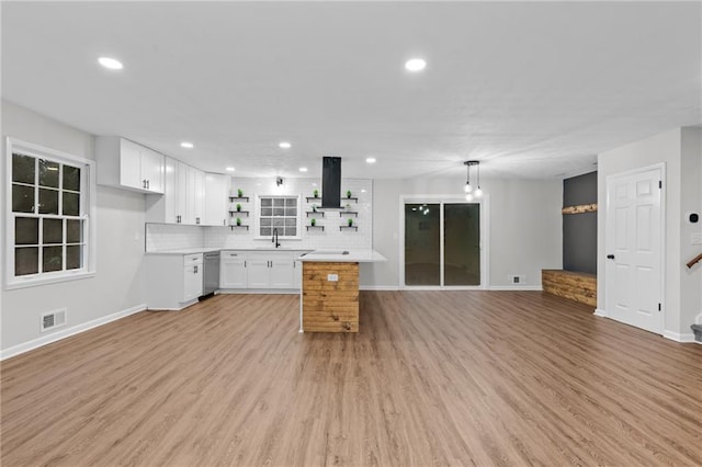 kitchen with dishwasher, hanging light fixtures, white cabinets, island exhaust hood, and light wood-type flooring