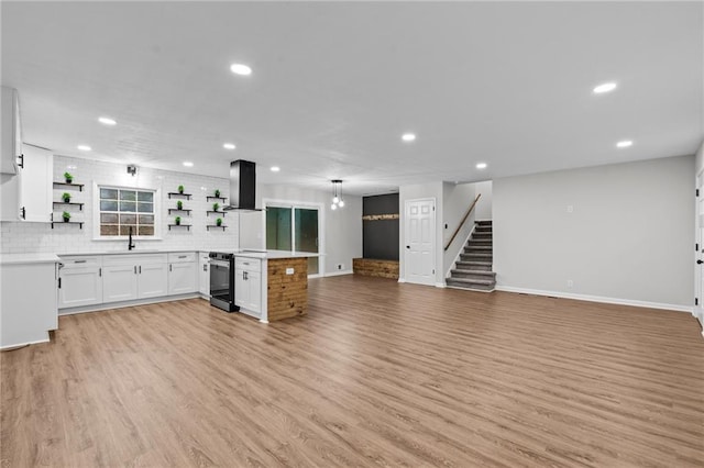 unfurnished living room featuring sink and light hardwood / wood-style floors