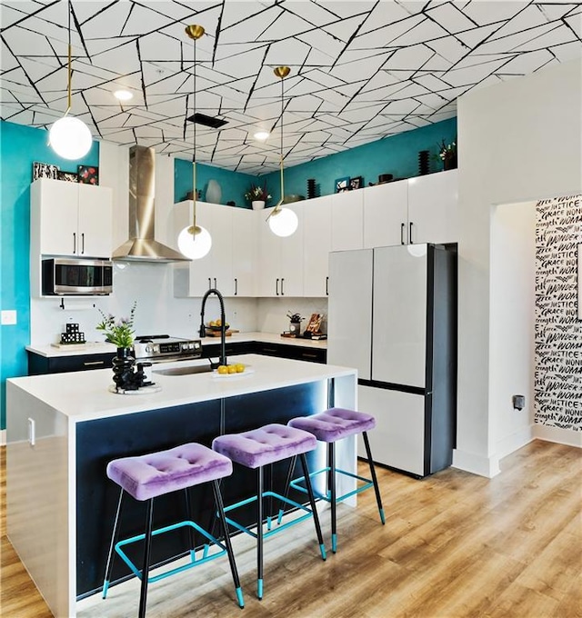 112 Rogers St NE Unit 505, Atlanta, GA 30317 - kitchen with freestanding refrigerator, wall chimney range hood, a sink, stainless steel microwave, and light countertops