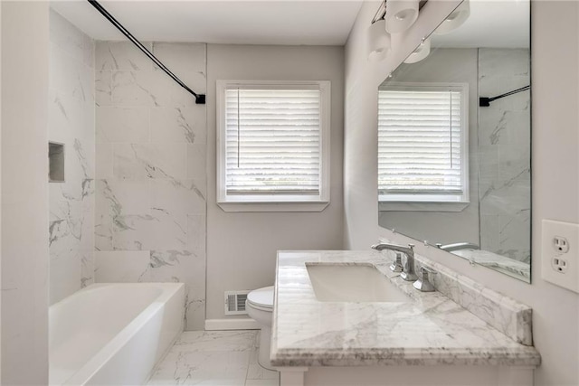 full bathroom featuring vanity, toilet, and tiled shower / bath