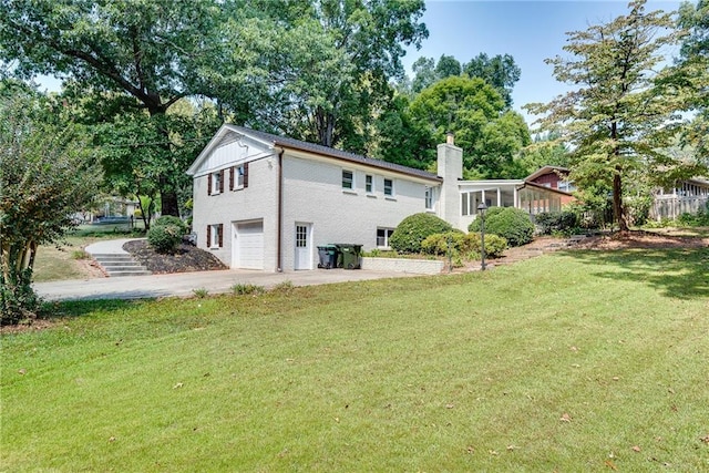 back of house featuring a garage and a lawn