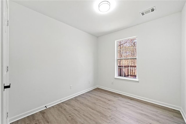 unfurnished room with visible vents, baseboards, and wood finished floors