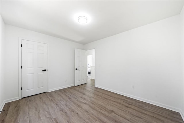 unfurnished bedroom with baseboards and wood finished floors