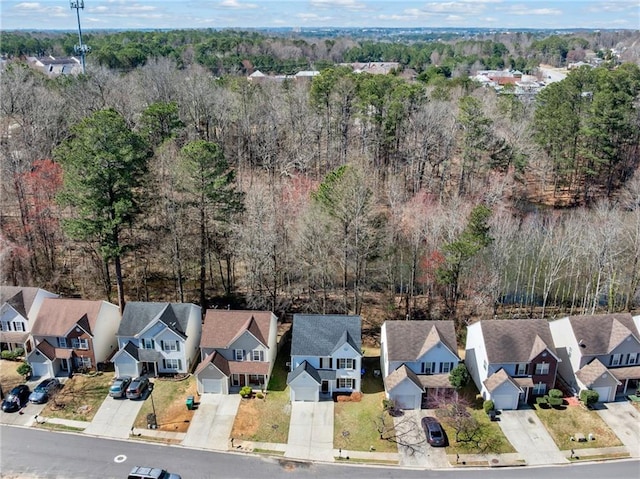 birds eye view of property featuring a residential view and a wooded view