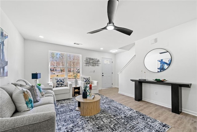 living area with visible vents, wood finished floors, baseboards, and ceiling fan