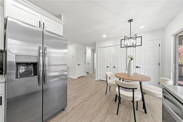 dining area featuring baseboards, recessed lighting, light wood-type flooring, and a chandelier