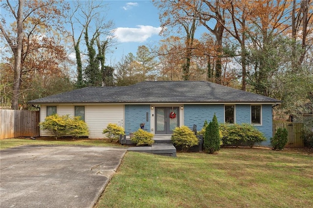 ranch-style house with brick siding, a front lawn, and fence