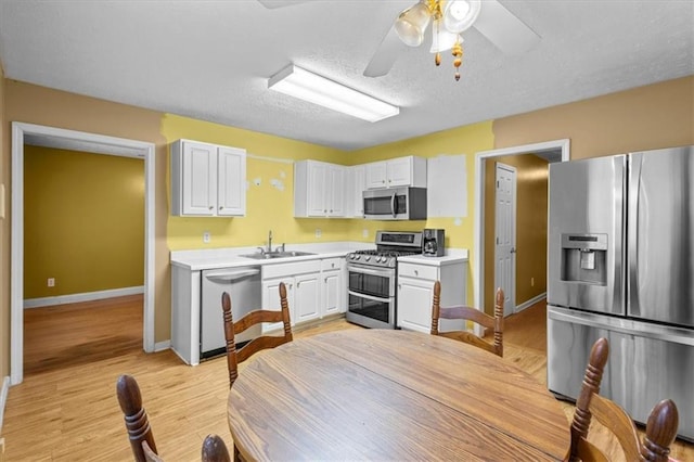 305 Hickory Pointe Ct, Villa Rica, GA 30180 - kitchen featuring stainless steel appliances, light countertops, white cabinetry, and a textured ceiling