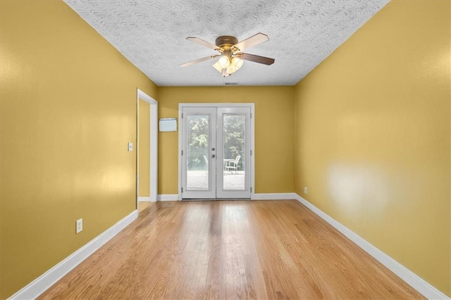 305 Hickory Pointe Ct, Villa Rica, GA 30180 - empty room with french doors, a ceiling fan, light wood-type flooring, and a textured ceiling
