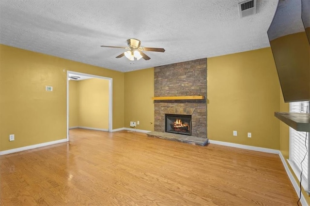 305 Hickory Pointe Ct, Villa Rica, GA 30180 - unfurnished living room featuring a fireplace, light wood-type flooring, a ceiling fan, and a textured ceiling