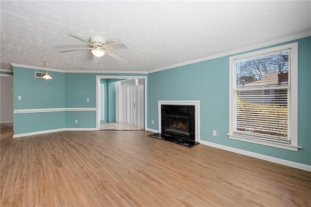 unfurnished living room with a textured ceiling, ornamental molding, wood finished floors, and a high end fireplace