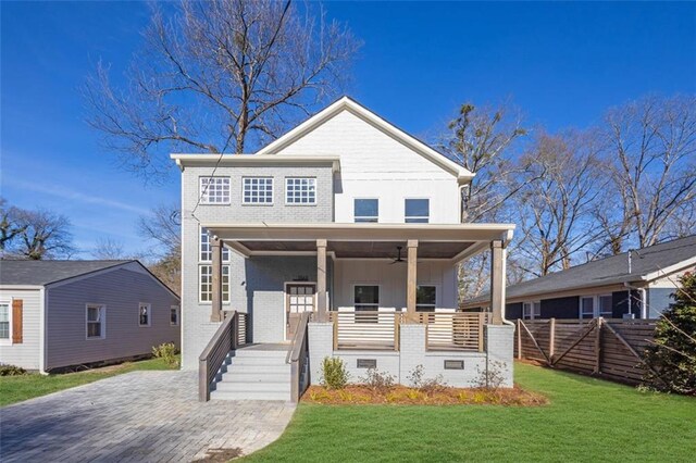 view of front of home with ceiling fan, covered porch, and a front lawn