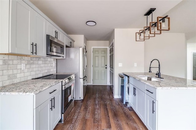 kitchen featuring pendant lighting, white cabinets, sink, dark hardwood / wood-style flooring, and stainless steel appliances