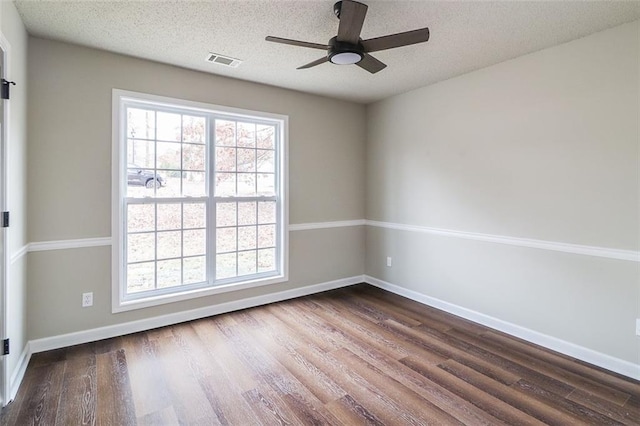 empty room with a textured ceiling, ceiling fan, and dark hardwood / wood-style floors