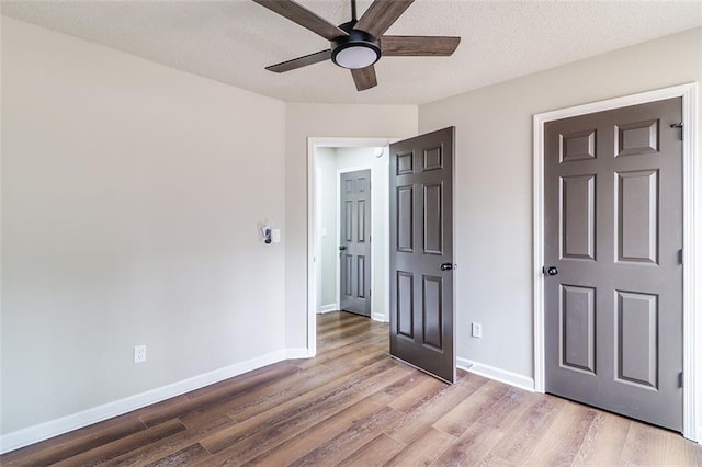 unfurnished bedroom with ceiling fan, light hardwood / wood-style flooring, and a textured ceiling