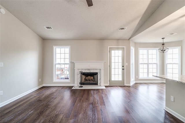 unfurnished living room featuring a fireplace, dark hardwood / wood-style flooring, and a textured ceiling