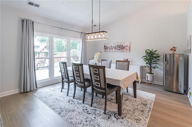 220 Chandler Ct, Sugar Hill, GA 30518 - dining space featuring a chandelier, light wood-type flooring, a textured ceiling, and lofted ceiling