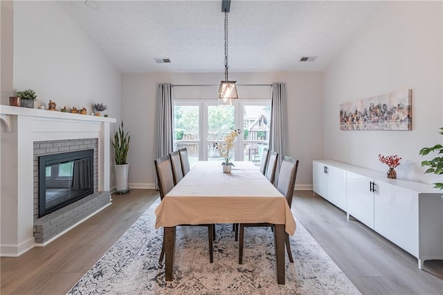 220 Chandler Ct, Sugar Hill, GA 30518 - dining space with a textured ceiling, light wood finished floors, and a fireplace