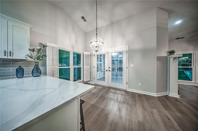 220 Chandler Ct, Sugar Hill, GA 30518 - unfurnished dining area with high vaulted ceiling, a chandelier, wood finished floors, and french doors