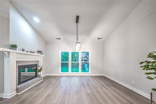 220 Chandler Ct, Sugar Hill, GA 30518 - unfurnished living room with wood finished floors, a fireplace, and a textured ceiling