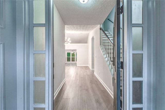 220 Chandler Ct, Sugar Hill, GA 30518 - corridor featuring stairs, wood finished floors, a textured ceiling, and a chandelier