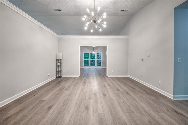 220 Chandler Ct, Sugar Hill, GA 30518 - unfurnished living room with a chandelier, wood finished floors, crown molding, a textured ceiling, and vaulted ceiling