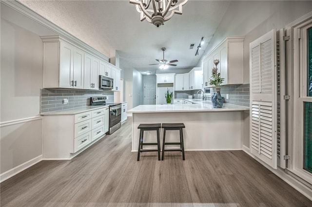 220 Chandler Ct, Sugar Hill, GA 30518 - kitchen featuring appliances with stainless steel finishes, light wood-type flooring, light countertops, and a chandelier
