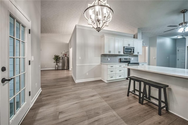 220 Chandler Ct, Sugar Hill, GA 30518 - kitchen with stainless steel appliances, a textured ceiling, wood finished floors, white cabinets, and backsplash