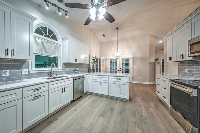 220 Chandler Ct, Sugar Hill, GA 30518 - kitchen with appliances with stainless steel finishes, ceiling fan, a peninsula, vaulted ceiling, and light countertops