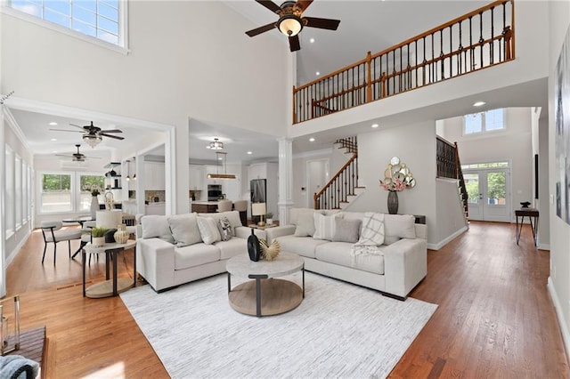 735 River Ridge Lane, Suwanee, GA 30024 - living room featuring ceiling fan, a towering ceiling, plenty of natural light, light wood-type flooring, and baseboards