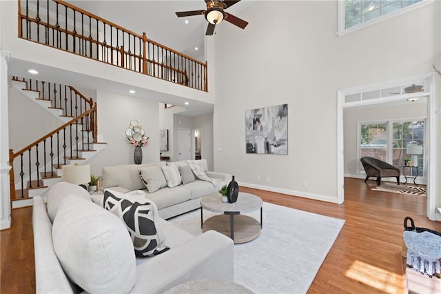 735 River Ridge Lane, Suwanee, GA 30024 - living room featuring a towering ceiling, wood finished floors, stairway, ceiling fan, and baseboards