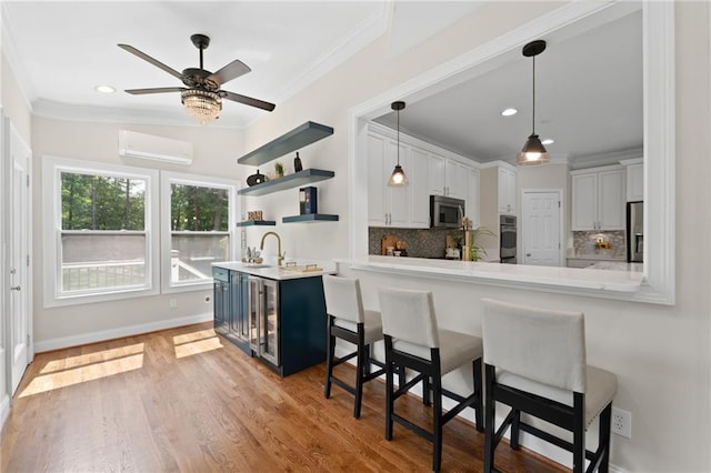 735 River Ridge Lane, Suwanee, GA 30024 - kitchen featuring an AC wall unit, crown molding, a kitchen breakfast bar, appliances with stainless steel finishes, and decorative backsplash