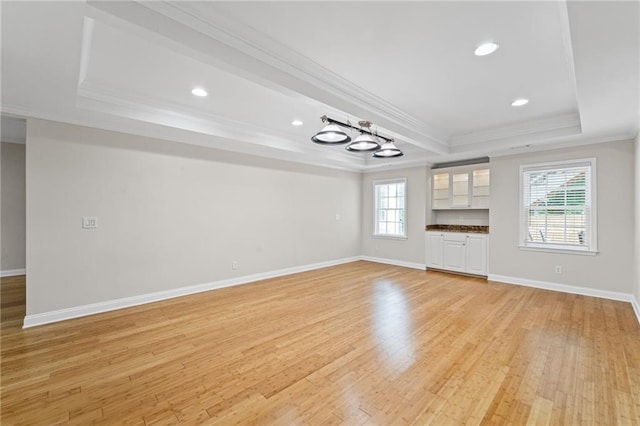 735 River Ridge Lane, Suwanee, GA 30024 - unfurnished living room with a raised ceiling, crown molding, light wood finished floors, baseboards, and recessed lighting