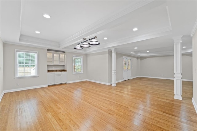 735 River Ridge Lane, Suwanee, GA 30024 - unfurnished living room with ornate columns, a raised ceiling, ornamental molding, light wood finished floors, and recessed lighting
