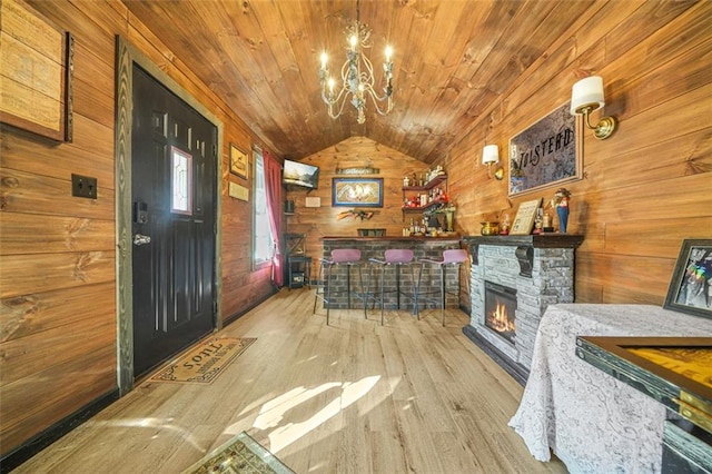 interior space featuring light hardwood / wood-style flooring, wood ceiling, vaulted ceiling, and wood walls