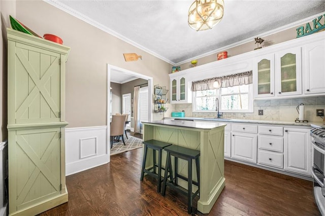 kitchen with white cabinetry, sink, dark wood-type flooring, and a kitchen bar