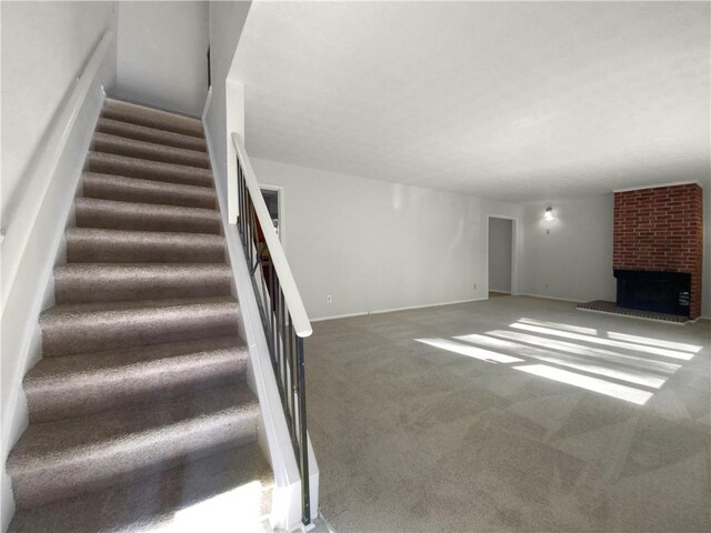 unfurnished living room with carpet floors and a brick fireplace