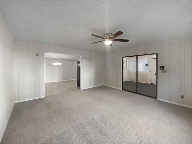 spare room with ceiling fan with notable chandelier, carpet floors, and a textured ceiling