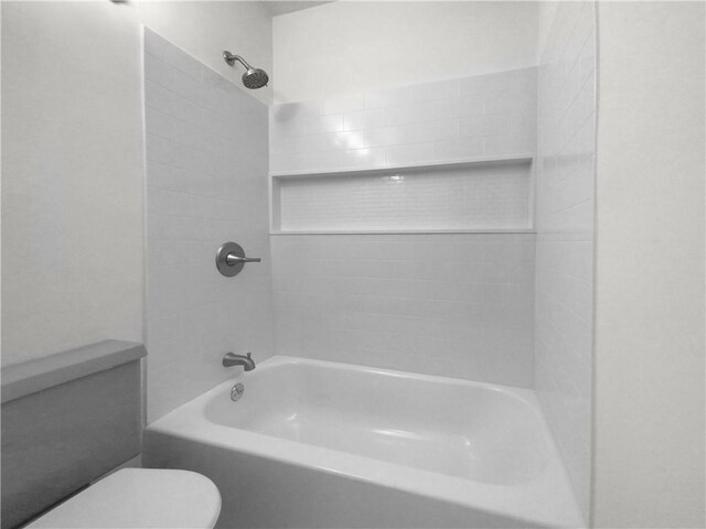 bathroom featuring toilet and tiled shower / bath