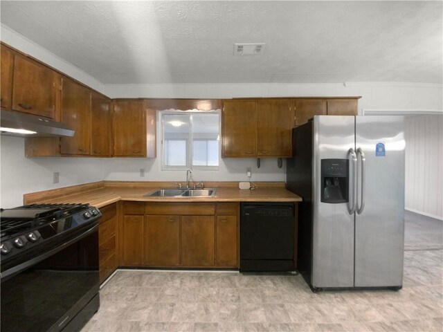 kitchen with black appliances, sink, and a textured ceiling