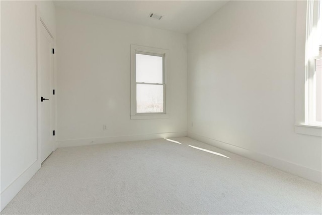 spare room with light colored carpet and plenty of natural light