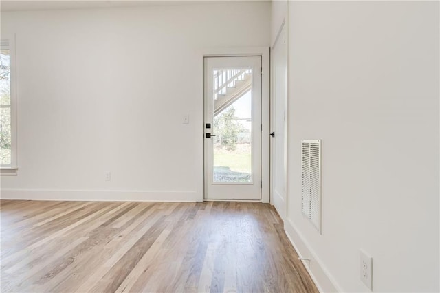 doorway to outside featuring a wealth of natural light and light hardwood / wood-style flooring